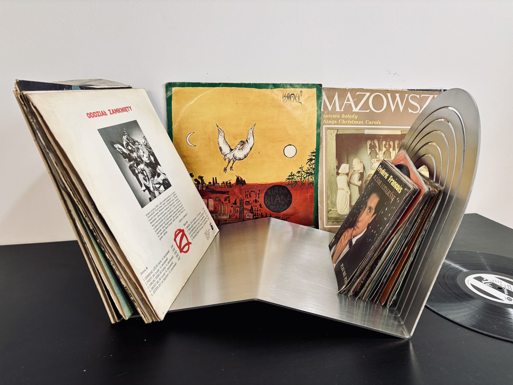 Collection of vinyl records and their covers displayed on a stand.