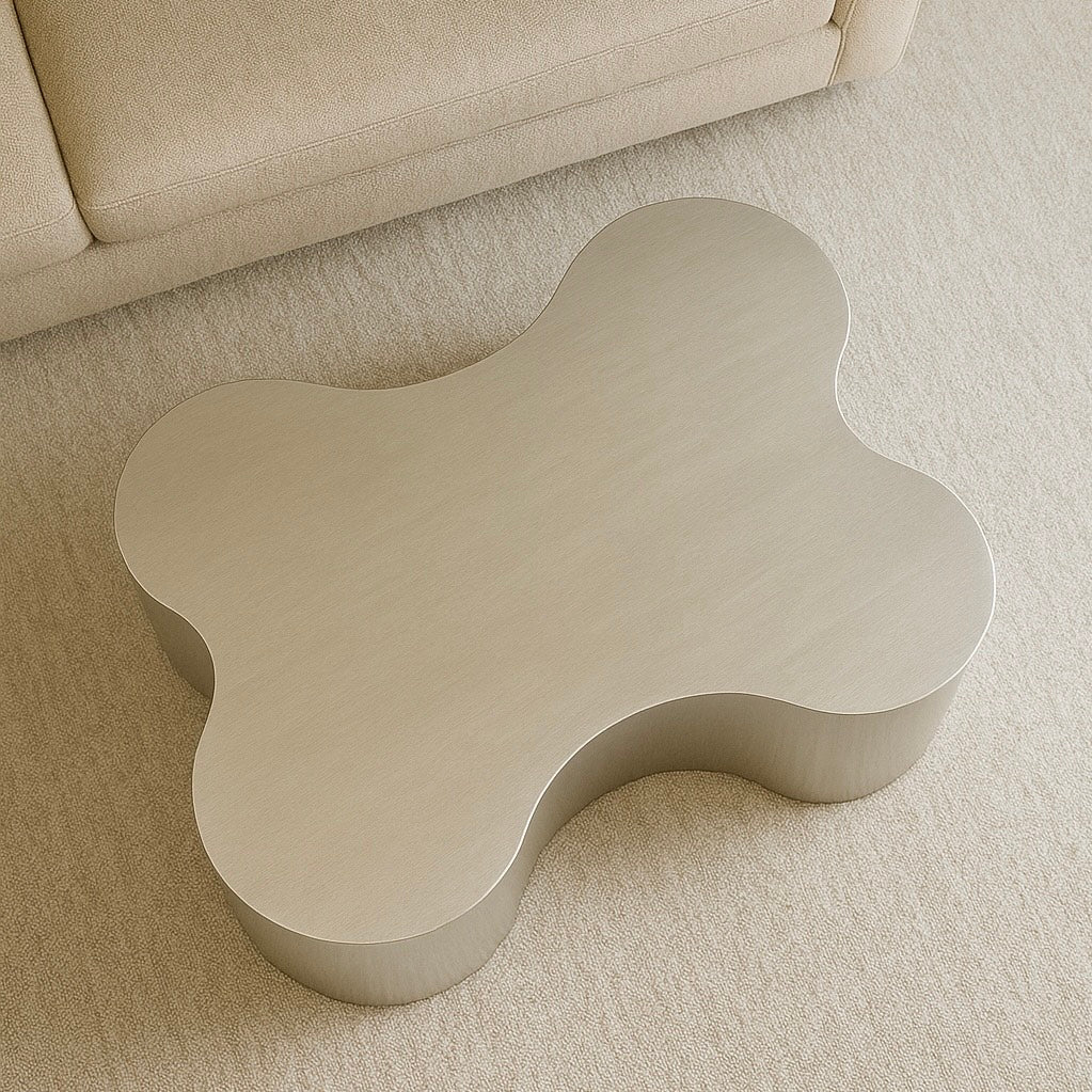 Beige wavy coffee table on a beige carpet with a beige sofa in the background