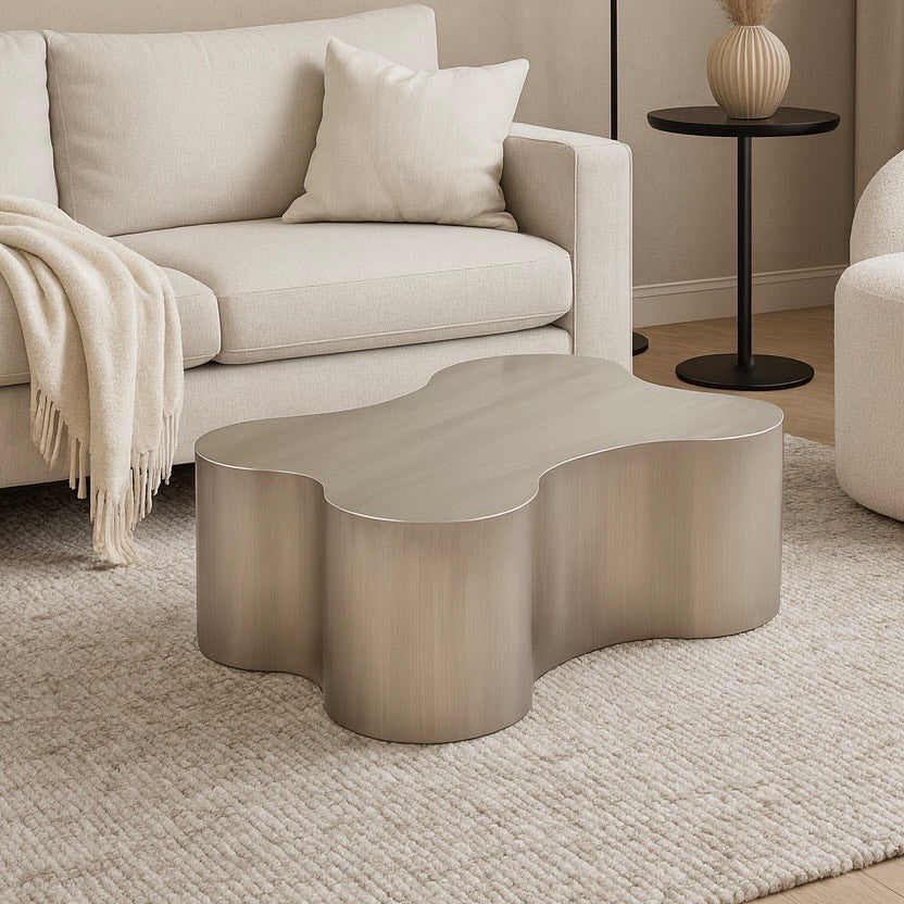 Modern living room with a wavy coffee table, beige sofa, and decorative elements.