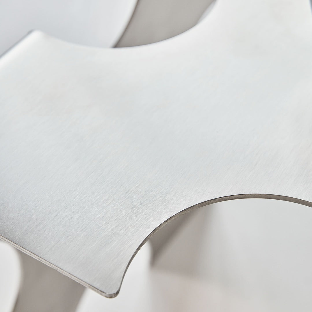 Close-up of the “Puzzle Table” by Veliento showing brushed stainless steel surface with smooth rounded edges and minimalist craftsmanship details.