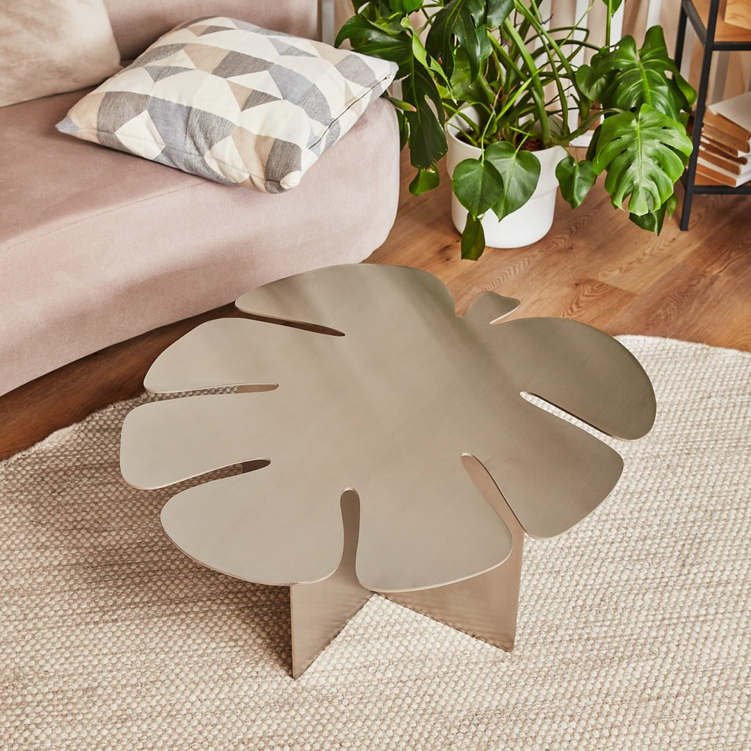 Minimalist coffee table inspired by Monstera leaf shape in modern living room.
