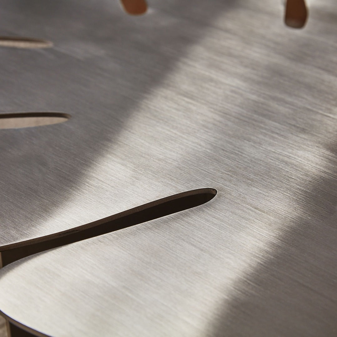 Elegant reflections on satin brushed stainless steel table surface.