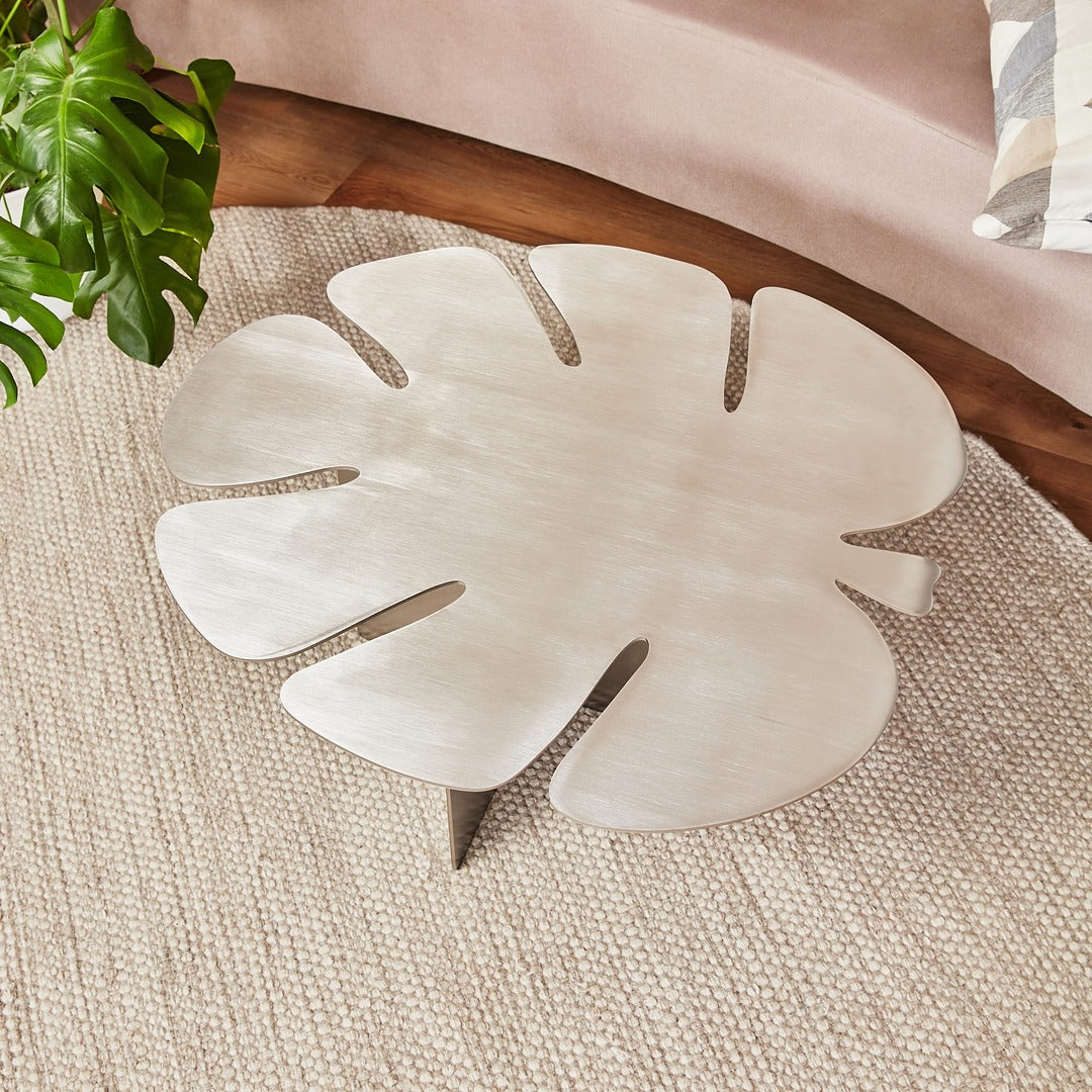 Top view of stainless steel Monstera leaf table showing organic silhouette and clean brushed finish.