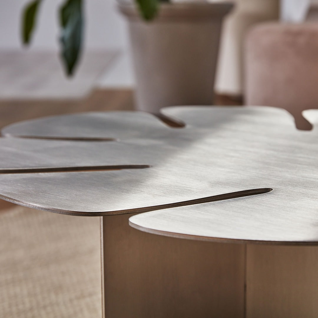 Sculptural brushed steel table as a centerpiece in contemporary home.