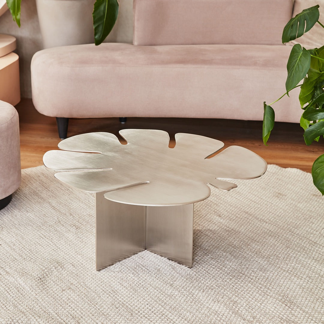 Modern brushed steel Monstera table adding a sculptural accent to a contemporary interior.